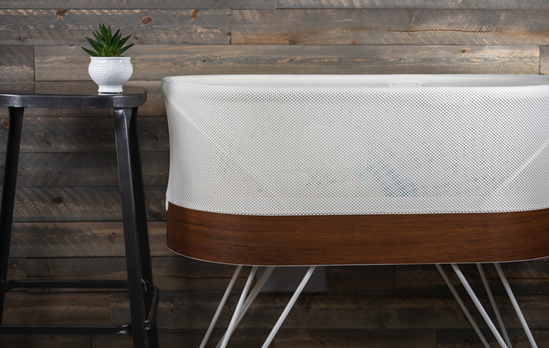 The Snoo smart bassinet against a wall